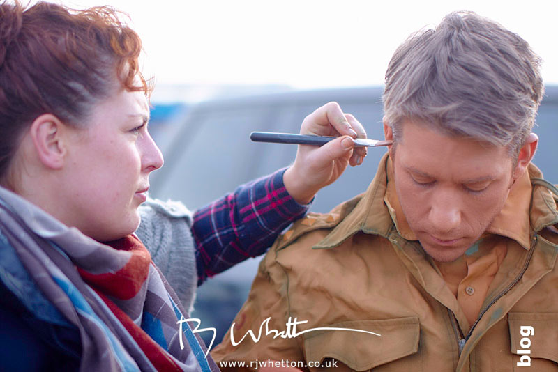 Rosie Lee adds final make-up to orange army man - Production Photography Dorset