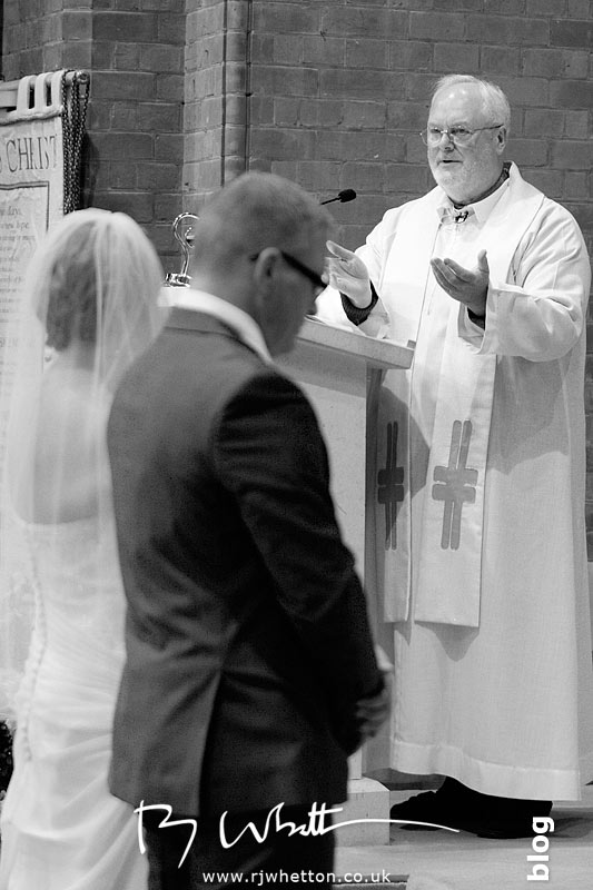 Father Denis giving the married couple some advice - Professional Wedding Photography Dorset
