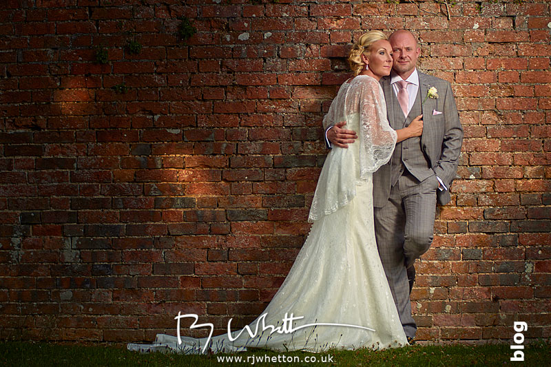 Sharon and Greg posing in front of an old wall at The East Close Hotel, Dorset - Wedding Photography Dorset